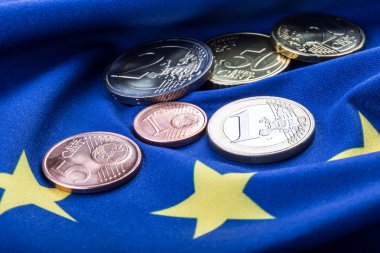 Greece and european  flag and euro money.  Coins and banknotes European currency freely laid on the European flag