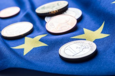 Greece and european  flag and euro money.  Coins and banknotes European currency freely laid on the European flag