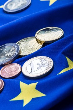 Greece and european  flag and euro money.  Coins and banknotes European currency freely laid on the European flag