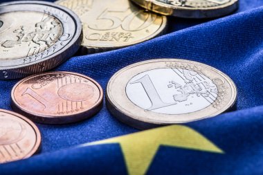 Greece and european  flag and euro money.  Coins and banknotes European currency freely laid on the European flag