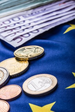 Greece and european  flag and euro money.  Coins and banknotes European currency freely laid on the European flag