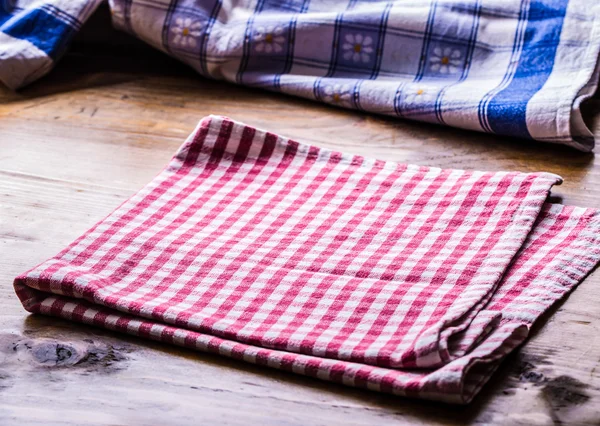 Red Canvas checkered cloth loosely laid on a wooden table — 图库照片