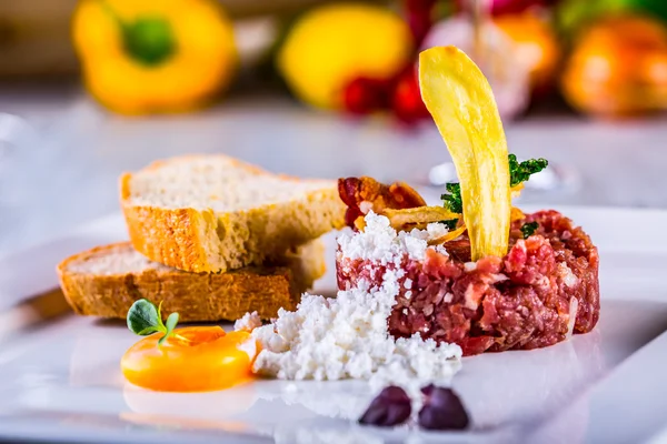 Carne cruda. Sabroso filete tártaro. Filete clásico tartar en plato blanco con pan de huevo y taza de vino tinto —  Fotos de Stock