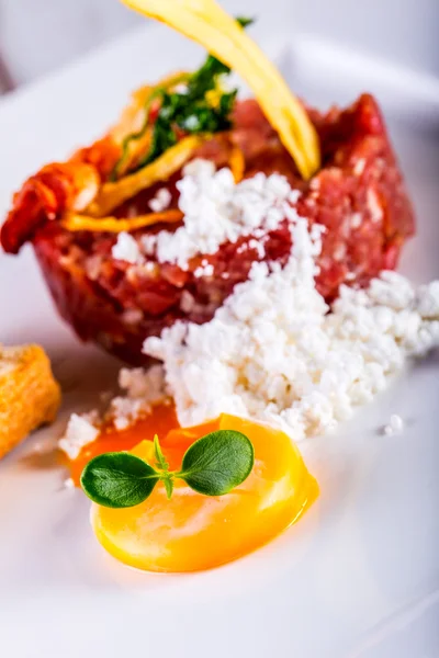 Carne cruda. Sabroso filete tártaro. Filete clásico tartar en plato blanco con pan de huevo y taza de vino tinto —  Fotos de Stock