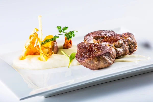 Стейк. Закрыть нежное мясо на гриле на белой тарелке с растительным декором . — стоковое фото