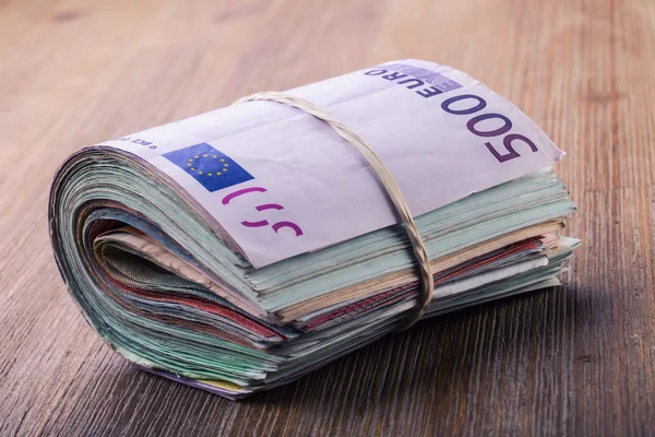 Euro money. Close-up Of A Rolled Euro Banknotes On Wooden table