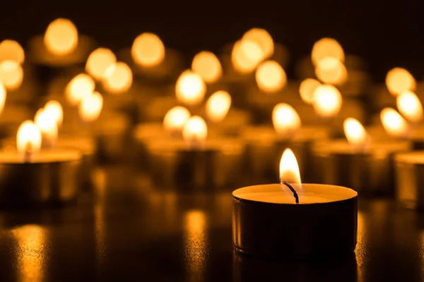 Luz dourada de chama de vela. Velas de Natal a arder à noite. Abstrato velas fundo . — Fotografia de Stock