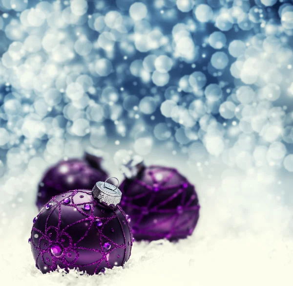 Kerstmis paarse ballen sneeuw en ruimte abstracte achtergrond. Feestelijke kerst abstracte achtergrond met bokeh intreepupil lichten. — Stockfoto