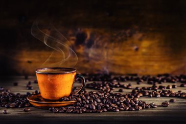 Kahve. Fincan sade kahve ve dökülen kahve çekirdekleri. Kahve molası