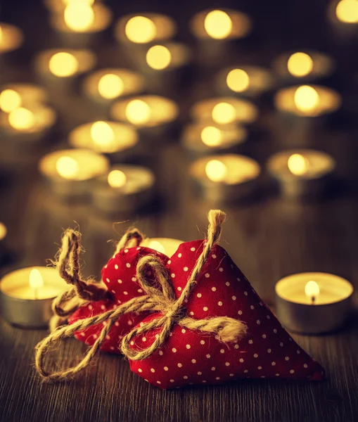 Δύο χειροποίητα valentine καρδιές, κάψιμο των κεριών, ρομαντική ατμόσφαιρα. Δύο καρδιές σε μια ξύλινη σανίδα. Ημέρα του Αγίου Βαλεντίνου. Ευχετήρια κάρτα του Αγίου Βαλεντίνου — Φωτογραφία Αρχείου