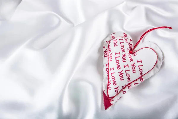 Valentines day. Hand made valentine heart. Wedding day. Red valentines hearts on white satin. Text: I love you — Zdjęcie stockowe