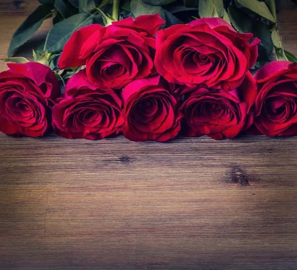 ¡Rose! Rosas rojas. Ramo de rosas rojas. Varias rosas sobre fondo de granito. San Valentín, fondo del día de la boda. pétalos de rosa y corazones cajas de regalo de San Valentín. San Valentín y frontera nupcial. Aguas gotas sobre rosas pétalos — Foto de Stock