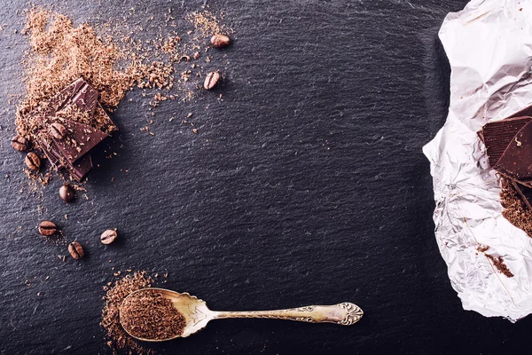 Chocolate. Black chocolate. A few cubes of black chocolate. Chocolate slabs spilled from grated chockolate powder