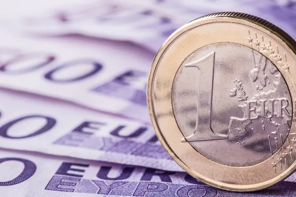 Verschillende 500 euro-bankbiljetten en -munten zijn naast. Symbolische foto voor wealt. Euromunt balanceren op stapel met achtergrond van bankbiljetten — Stockfoto