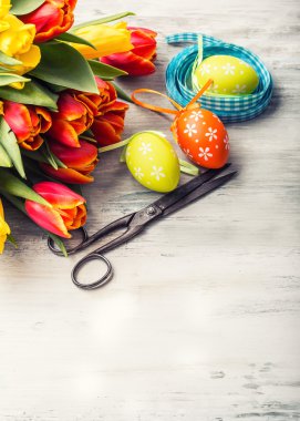 Mutlu paskalyalar. Çok renkli bahar laleler ve Paskalya yumurtası. Bahar ve Paskalya süsleri.