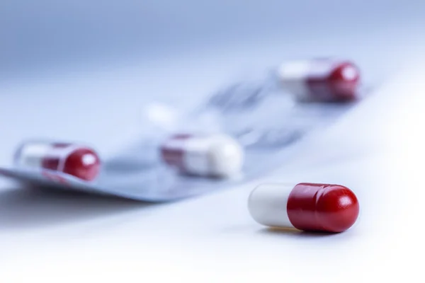 Pills. Tablets. Capsule. Heap of pills. Medical background. Close-up of pile of red white tablets - capsule. Pills and tablets.Blue background — Stockfoto