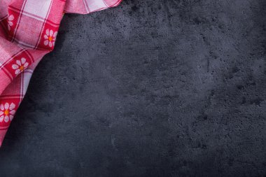Top view of checkered kitchen tablecloth on granite -  concrete - stone background. Free space for your text or products