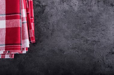 Top view of checkered kitchen tablecloth on granite -  concrete - stone background. Free space for your text or products
