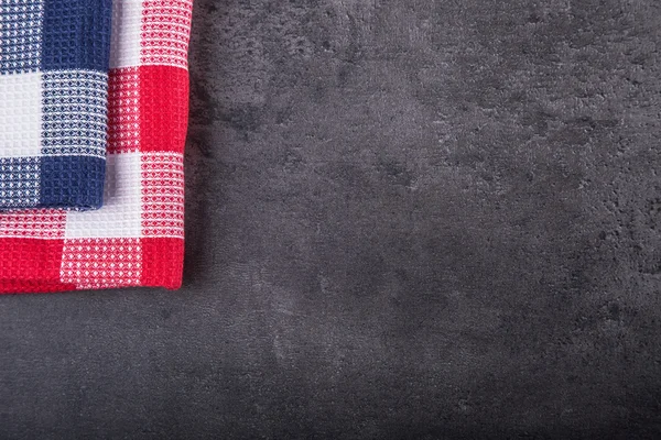 Top view of checkered kitchen tablecloth on granite -  concrete - stone background. Free space for your text or products — Zdjęcie stockowe