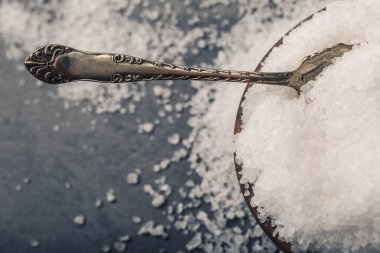Salt. Coarse grained sea salt on granite - concrete  stone background with vintage spoon and wooden bowl