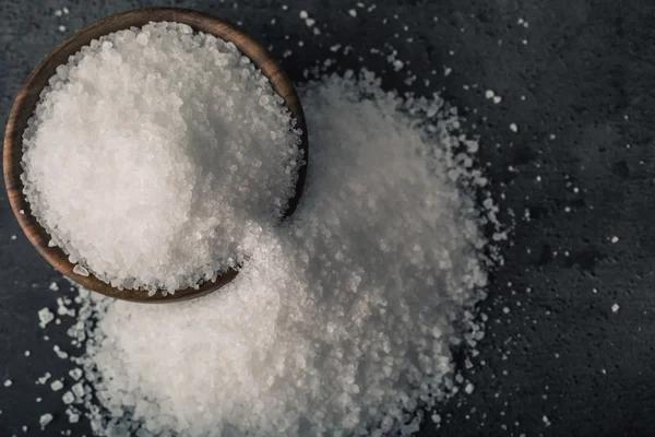 Salt. Coarse grained sea salt on granite - concrete  stone background with vintage spoon and wooden bowl — Φωτογραφία Αρχείου