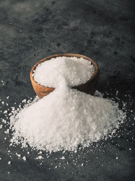 Salt. Coarse grained sea salt on granite - concrete  stone background with vintage spoon and wooden bowl — Φωτογραφία Αρχείου