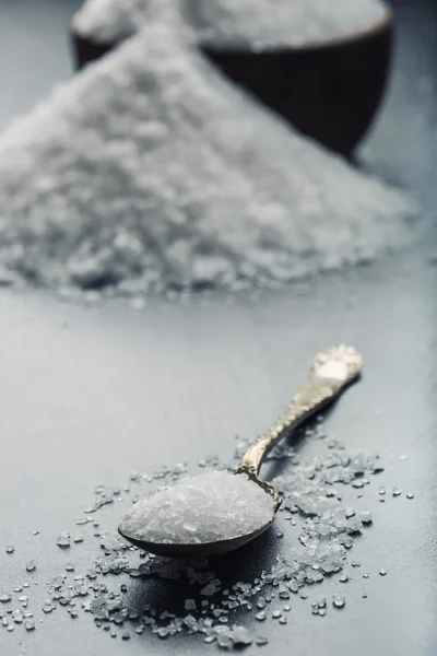 Garam. Garam laut berbutir kasar pada granit - latar belakang batu beton dengan sendok vintage dan mangkuk kayu — Stok Foto