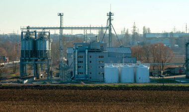 Bir tarım endüstrisi kompleksinin panoraması önünde hasat üstüne hasat.
