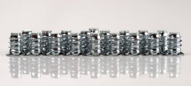 Açık gri arka planda bir sıra mobilya vidaları ile panoramik fotoğraf.