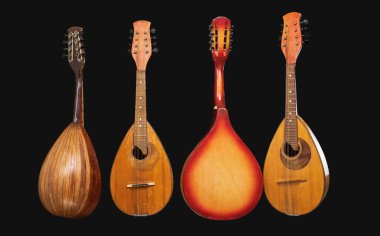 Siyah arka planda dört farklı eski mandolin..