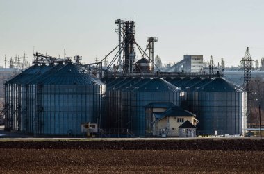 Bir tarlası ve tahıl kurutmak ve depolamak için asansörü olan kırsal bir arazi..