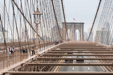 New York City, ABD - 6 Ağustos 2019: İnsanlar bulutlu bir günde Brooklyn Köprüsü 'nü yürüyerek geçerler.
