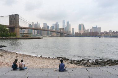 New York City, ABD - 6 Ağustos 2019: İnsanlar Brooklyn Köprüsü 'ne ve Brooklyn Köprüsü' nün New York siluetine, sisli bir günde hayran..