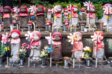 Tokyo, Japan-august 6, 2024:front view of statues with pinwheels inside the garden of the Zojoji temple in Tokyo during a day of sightseeing
