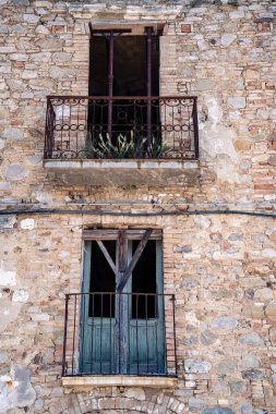 Craco, İtalya-25 Nisan 2025: Güneşli bir günde İtalya 'nın yıkık dökük Craco kentinin evlerinin pencere ve balkonları