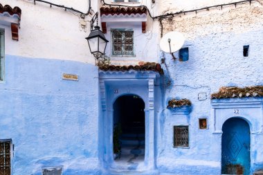 Chefchaouen, Fas - 26 Mart 2024: Bulutlu bir günde, Fas 'ın tipik bir kasabası olan Chefchaouen' da tipik bir mavi evin girişi