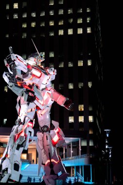 Tokyo, Japonya-Ağustos 6, 2024: Geceleyin Odaiba Sahil Parkı bölgesinde Gundam robot heykelinin müzik ve gece lambalarıyla dikey fotoğrafı