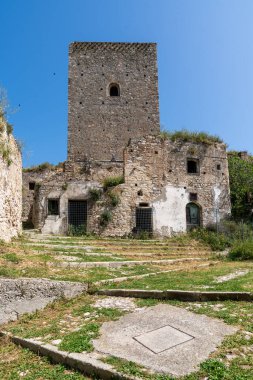 Craco, İtalya-25 Nisan 2025: Norman Kulesi bir yaz günü hayalet şehir Craco 'nun yıkılmış binaları arasında dikey fotoğraf kulesi