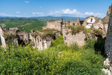 Craco, İtalya-25 Nisan 2025: Sicilya 'nın hayalet kasabası Craco' daki harabeler bir Nisan günü bir tepenin üzerine tünedi ve çiçeklerle çevrildi.