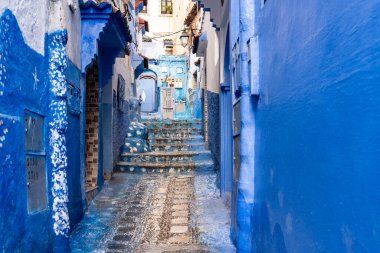 Chefchaouen, Fas - 26 Mart 2024: Bir Mart günü Fas 'ın mavi şehrindeki bir eve giden renkli merdivenler.