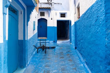 Chefchaouen, Fas - 26 Mart 2024: Mavi kapılar ve Fas 'ın mavi şehrinde bir sokakta bir araba Mart günü