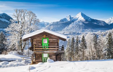 Winter wonderland in the Alps with traditional mountain chalet clipart