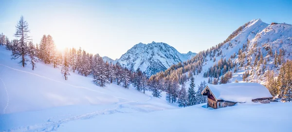 Winter wonderland in the Alps with mountain chalet at sunset — Stock Photo, Image