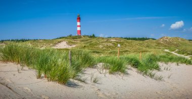 Beautiful dune landscape with traditional lighthouse at German North Sea clipart