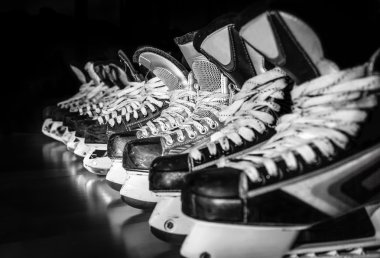 Hockey skates lined up in locker room clipart
