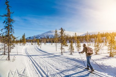 Turist İskandinavya'nda kayaklı günbatımı