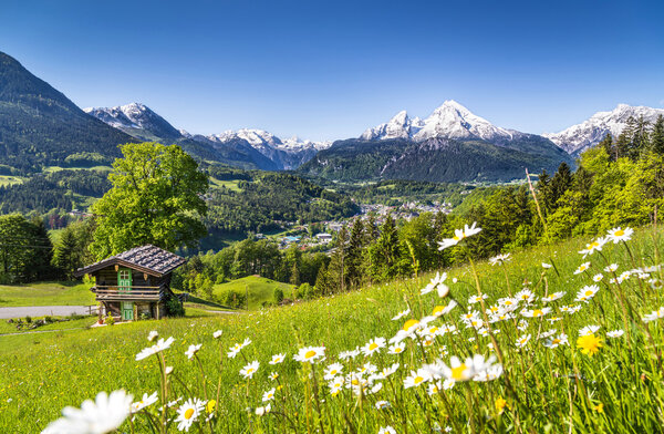 Idyllic mountain landscape in the Alps with traditional mountain lodge in spring
