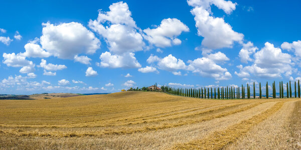Beautiful Tuscany landscape with traditional farm house and dramatic clouds on a sunny day in Val d 'Orcia, Italy
