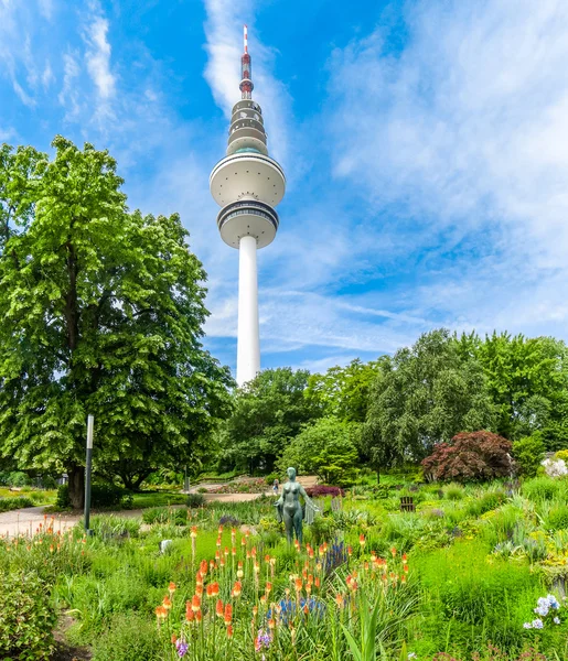 Prachtig uitzicht op de bloementuin in plants um Blomen park met de beroemde toren van de telecommunicatie van Heinrich-Hertz-Turm radio op de achtergrond, Hamburg, Duitsland — Stockfoto