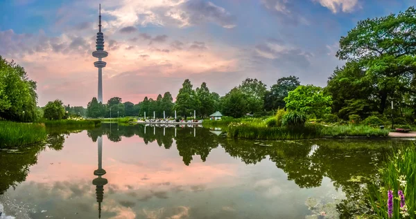 プランテンのフラワー ガーデンの美しい景色 um Blomen 公園バック グラウンドでハインリヒ ・ ヘルツ塔ラジオ通信塔が有名な夕暮れ時、ハンブルク、ドイツ — ストック写真